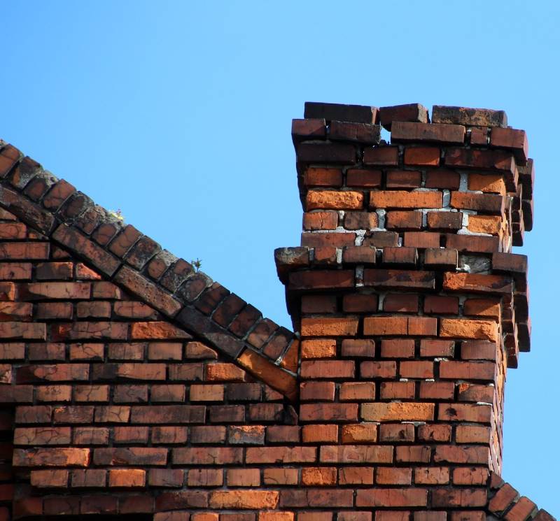 Damaged chimney on an Ray home showing cracks and missing mortar